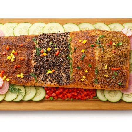 Tri-flavored side of salmon platter on a wood board with cucumbers